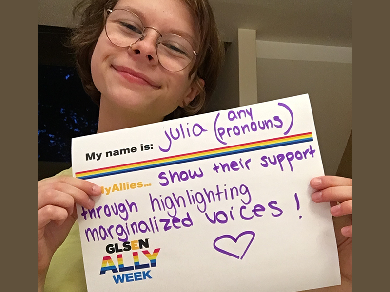 This student is holding up a sign that says: My name is Julia (any pronouns). My allies show their support trough highlighting marginalized voices!