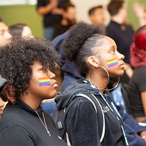 Students at a Day of Silence Rally with rainbow stickers on their faces