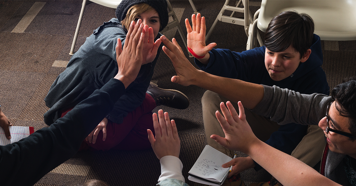 Students high-fiving in a classroom