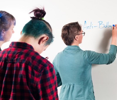 Teacher explaining to students at whiteboard