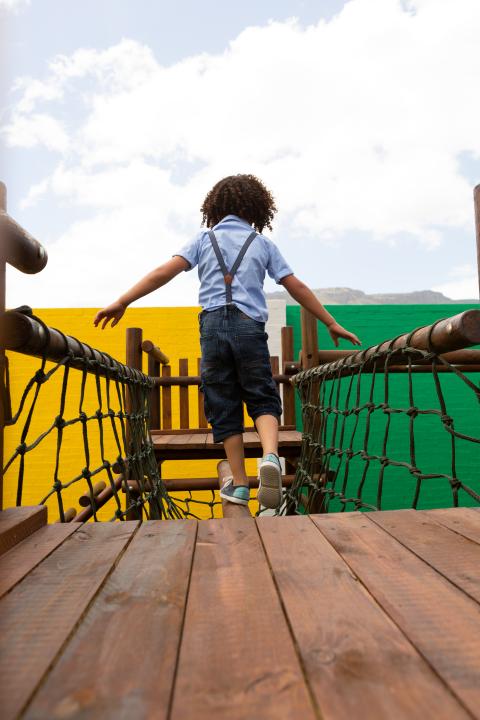 A young student playing on a playground.