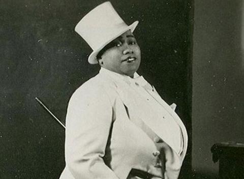 Photo of Gladys Bentley wearing an a all white tuxedo. 